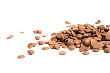 Naklejka premium Close up of tMilk chocolate chips. Scattered chocolate callets isolated on white. Texture of chocolate