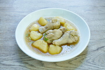 boiled chicken leg with potato in gravy sauce stew on plate