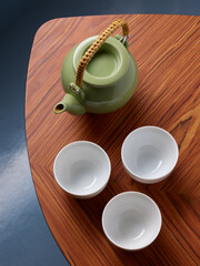 Set of porcelain teapot and cups on wooden table