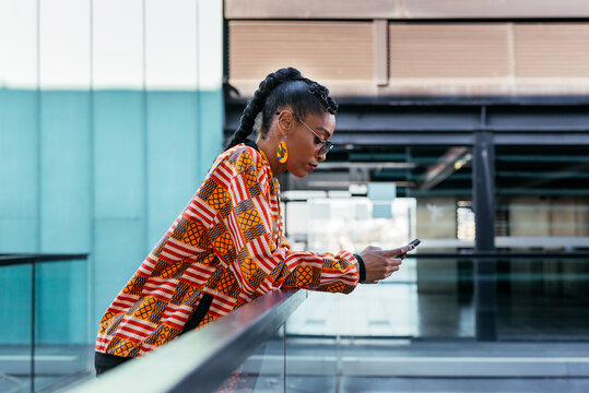 Trendy woman using smartphone on terrace