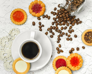black coffee in a white cup muffin biscuits on the table and coffee beans scattered view from...