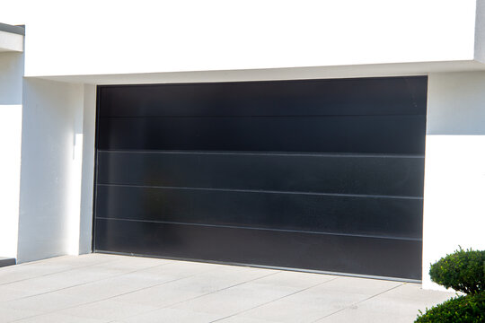 Neues schwarzes Garagentor (Sektionaltor) an einem Wohnhaus