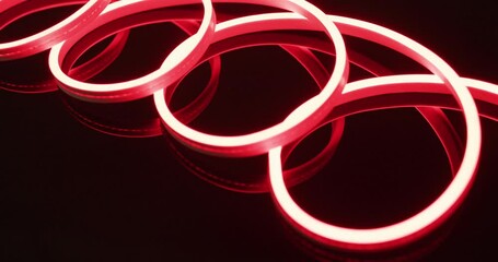 Animation of red neon lights forming spiral over black background