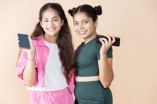 two girls with phone in hand studio shot 