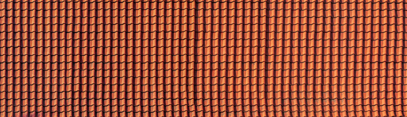 panorama of antique clay red roof tiles of an ancient house, close-up of the repeating wave pattern...