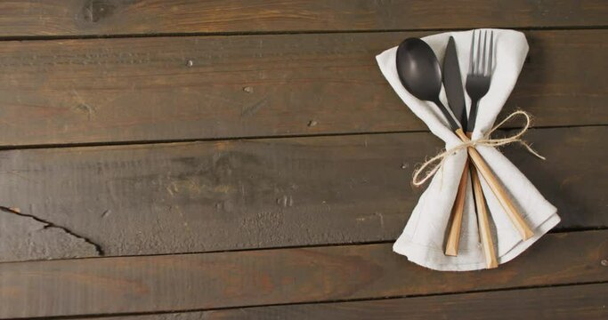 Video of cutlery and cloth lying on wooden surface