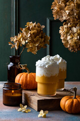 Spicy pumpkin latte with whipped cream. Autumn or winter hot coffee drink with cinnamon, nutmeg