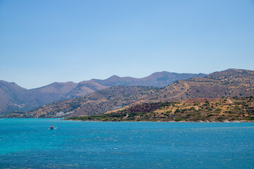 Fototapeta premium Turquoise blue sea panoramic view with a mountain in the background
