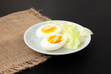 Hard boiled eggs on a plate with salad greens