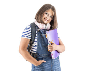 Cute and smiling schoolgirl in glasses with backpack and headphones holds study materials and a pen
