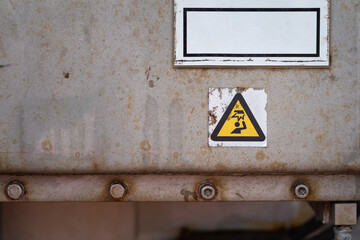 Attention "head injury" icon sign which is attached on the metal surface of machiner part. Industrial safety symbol object.