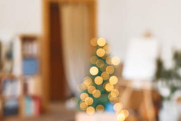 Defocused Christmas tree with lights in festive living room blurred view. Blurred holiday background.