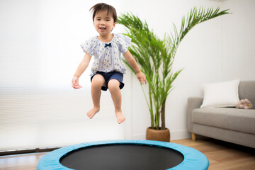 トランポリンでジャンプして遊ぶ2歳の女の子