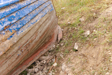 Remains of an old wooden boat. The bow of the wooden boat is stuck in the coastal rocks.