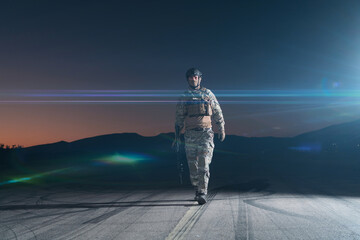 Army soldier in Combat Uniforms with an assault rifle, plate carrier and combat helmet going on a...