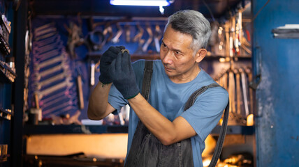 Fototapeta na wymiar Portrait senior asian male mechanic engineering working on tools box background. Repair specialist, technical maintenance. Small business owner.