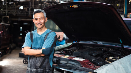 Fototapeta na wymiar Portrait senior asian male mechanic engineering working on Vehicle in a Car Service. Repair specialist, technical maintenance. Small business owner.