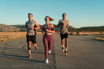 Three runners sprinting outdoors - Sportive people training in a urban area, healthy lifestyle and sport concepts - obrazy, fototapety, plakaty