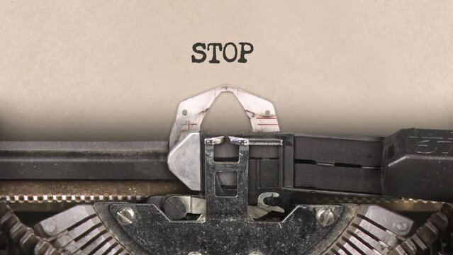 Old retro typewriter with sheet of paper. Close up. Word. Writing text Stop. With machine sounds. 29,97 fps