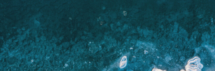 Top view of the freezing sea. Winter aerial view of ice floes in blue sea water. Northern nature....