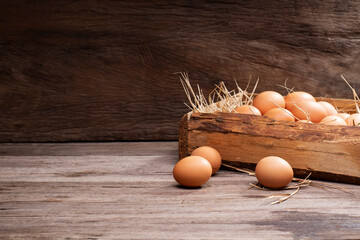 Chicken eggs are laid on the ground and put in a basket on a wooden table on, a rural farm - Powered by Adobe