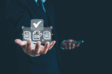Businessman using smartphone with virtual screen and document for online approve paperless quality assurance and ERP management concept, online document management system concept.
