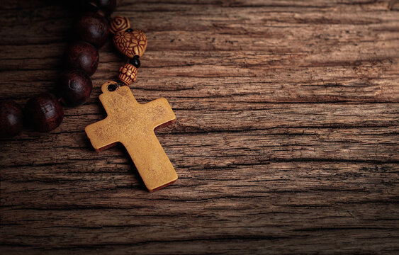 Christian wooden crucifix with Wooden rosary on open bible, Religious concept image,