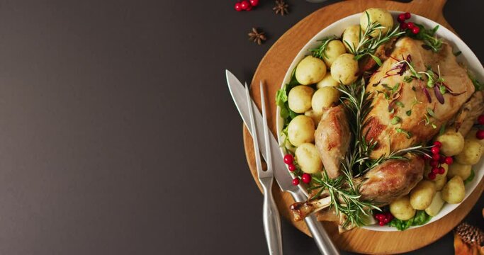 Video of tray with roasted turkey, potatoes and cutlery on grey surface