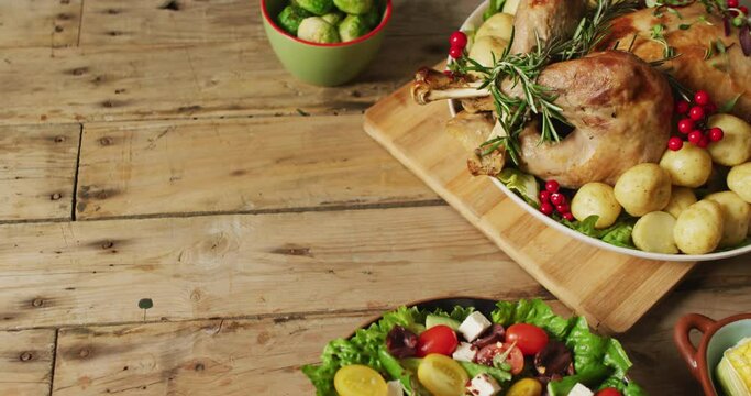 Video of tray with roasted turkey, potatoes and vegetables on wooden surface