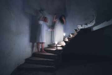Husband and wife fighting on the stairs of an old, creepy house