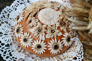 Chleb dożynkowy i komunijny udekorowany zbożami