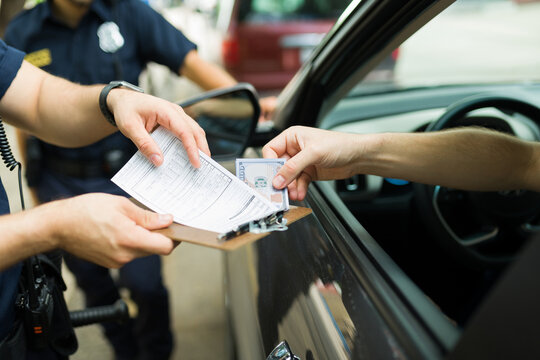 Closeup of police officers receiving a bribe for a speeding ticket