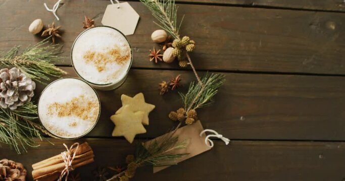 Video of cups of hot chocolate with cinnamon over wooden background