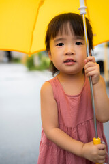 雨の日に傘をさしている2歳の子供