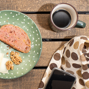 Tostada con pan con tomate, nueces y trozo de queso, desayuno con movil y caf&eacute;, nutritivo y saludable