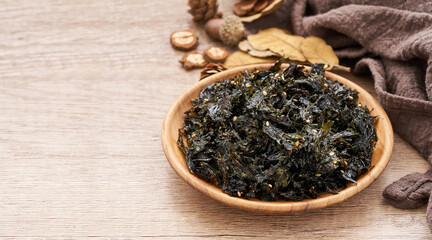 roasted nori seaweed and sesame topping in wood plate on wooden table background. Gim, laver, nori                                                                      