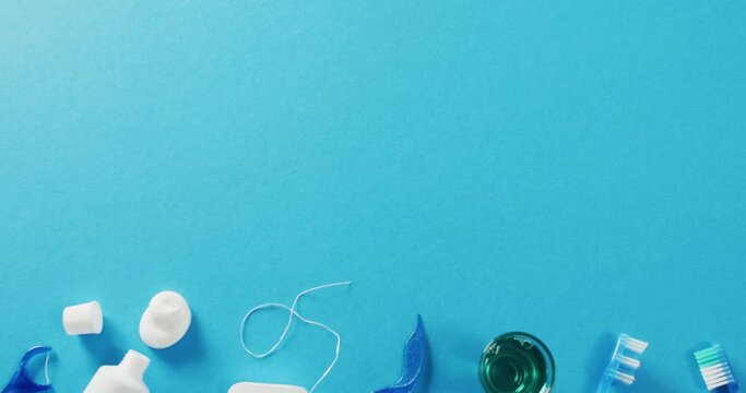 Video of close up of toothbrush and floss on blue background