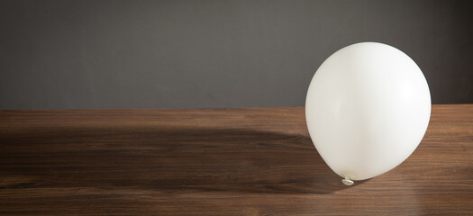 White balloon on the wooden table. © andranik123