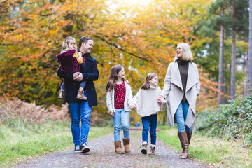 Beautiful family enjoying walk in the wood in autumn - 530354506
