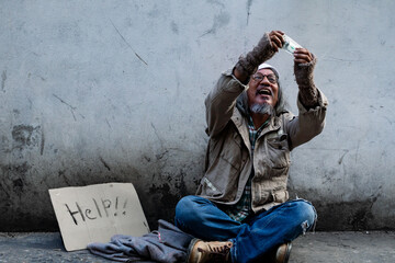  Asian homeless man rejoices after receiving banknotes from passersby to help. man long hair,...