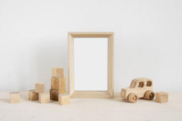 Baby photo frame mockup with wooden toys and cubes.