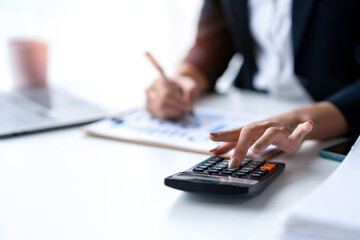 finance and accounting concept. woman hand press on a calculator to make a financial report or company's profit monthly at the