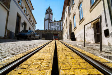 Tram track and tram car parked at the base from the point of view of the track from the bottom to the top of the hill. Viseu. - obrazy, fototapety, plakaty