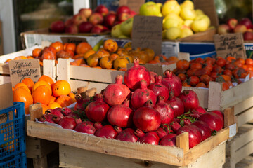 A red ripe pomegranate on the counter of a street vegetable store