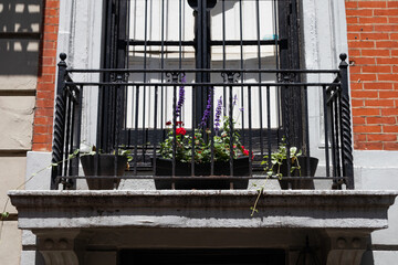 Fototapeta na wymiar Large Window Sill with Potted Plants on an Old Brick Building in the East Village of New York City
