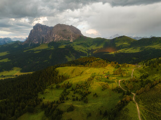 Fototapeta premium Sunrise in the Dolomites mountains with fog and mist rolling around the peaks. Hiking path leading to the hills. 