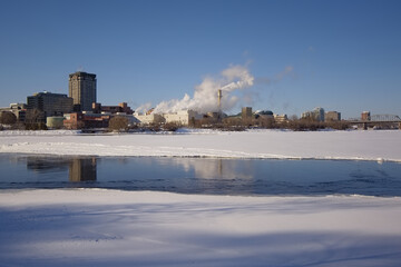 Frozen Ottawa river with skyscrapers, history museum and industrial buildings of Gatineau on the other side