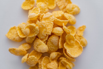close up view of dry and crispy corn flakes isolated on white.