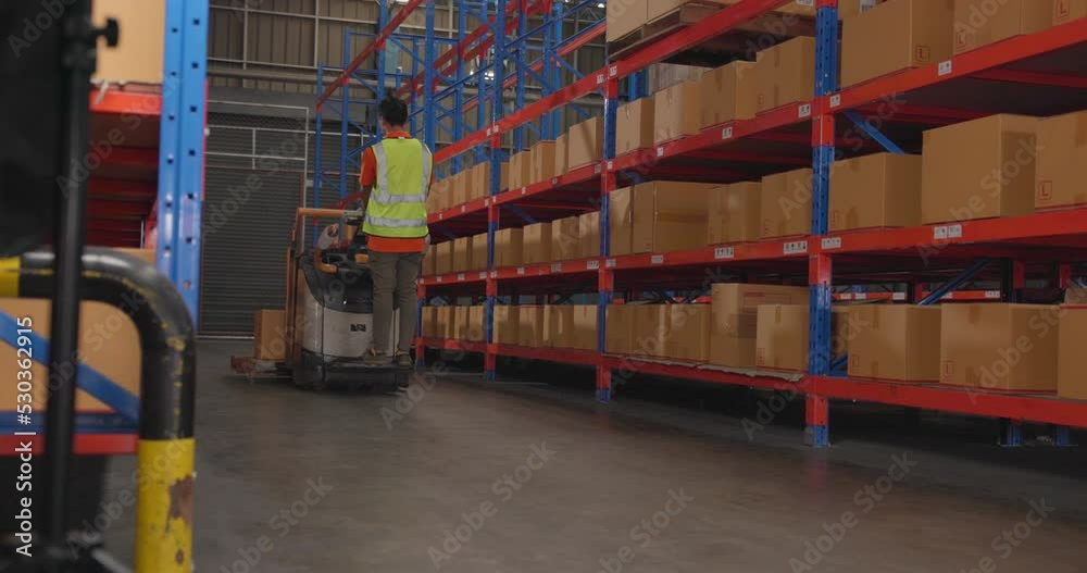 Wall mural factory workers deliver boxes and packages in the warehouse using a pushing auto cart.