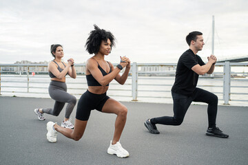 Team friends athlete training exercises in sportswear. Fitness bracelet watch on the arm.